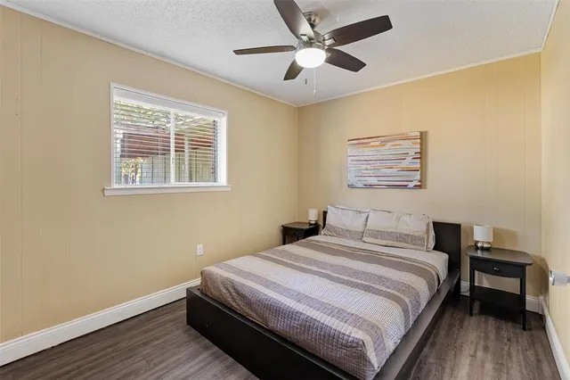 a bedroom with a large bed chandelier and a window