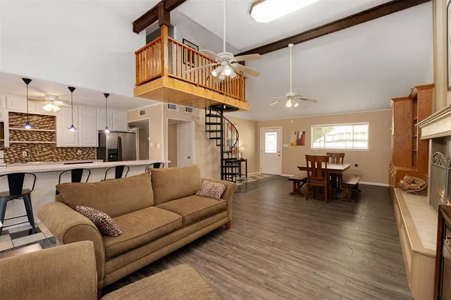 a living room with furniture and a dining table with kitchen view