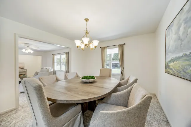 a view of a dining room with furniture and chandelier