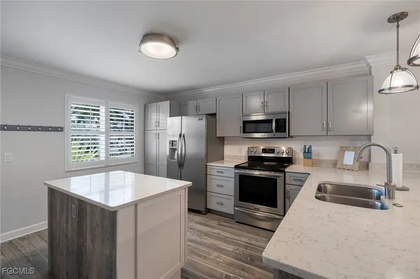 a kitchen with stainless steel appliances granite countertop a sink stove and refrigerator