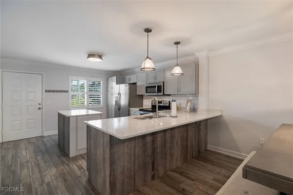 a kitchen with kitchen island a sink and wooden floor