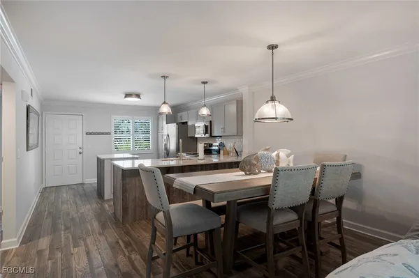 a dining room with furniture a chandelier and wooden floor
