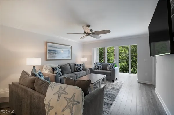 a living room with furniture a large window and a flat screen tv
