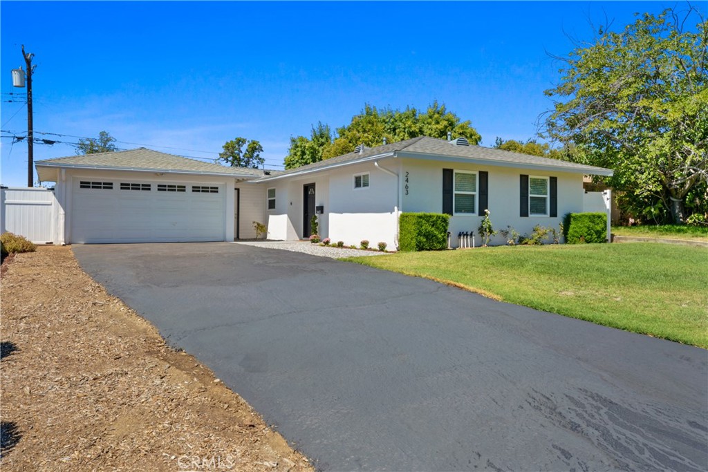 2463 Valhalla Street Pomona, CA 91767 - Photo 2 of 18 a front view of a house with a yard and garage