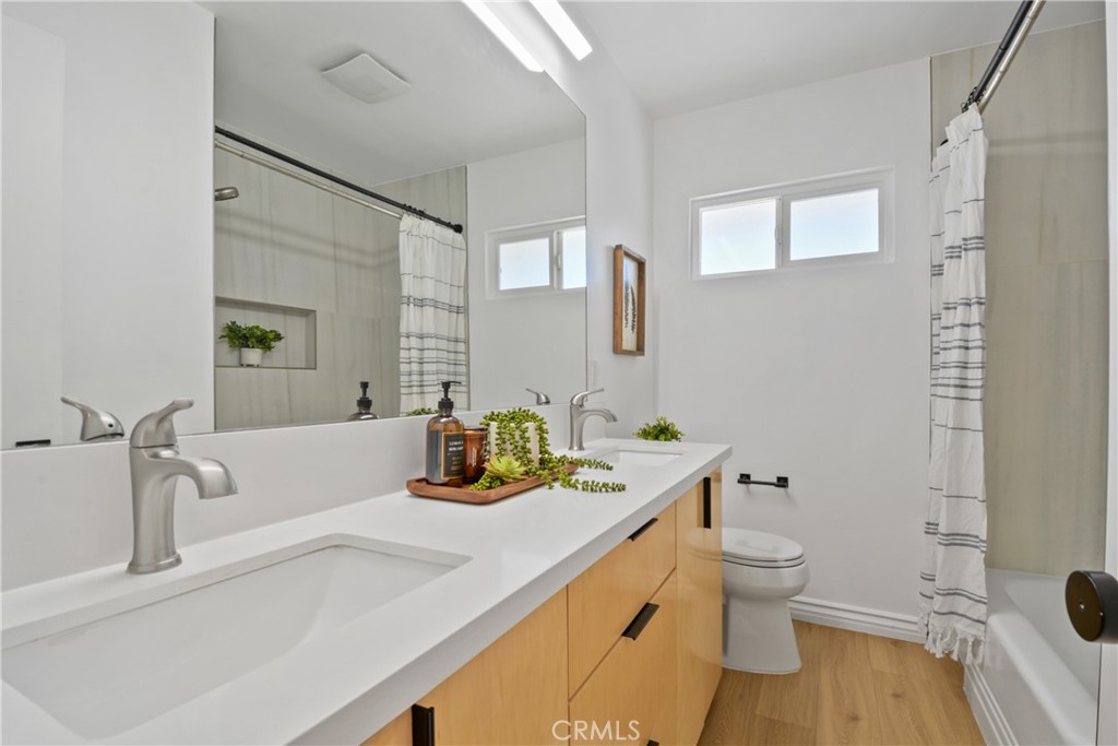2463 Valhalla Street Pomona, CA 91767 - Photo 10 of 18 a bathroom with a granite countertop sink mirror vanity and toilet