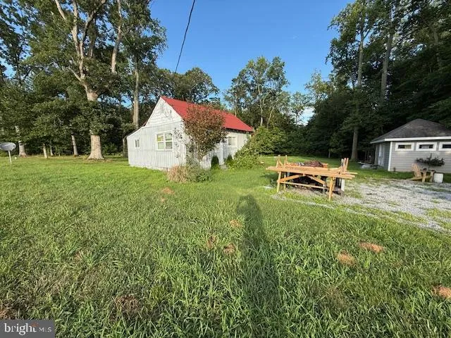 a front view of a house with a garden and trees
