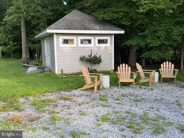 a front view of a house with a yard chairs and a fountain
