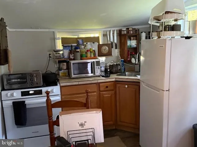 a kitchen with a refrigerator and a stove top oven