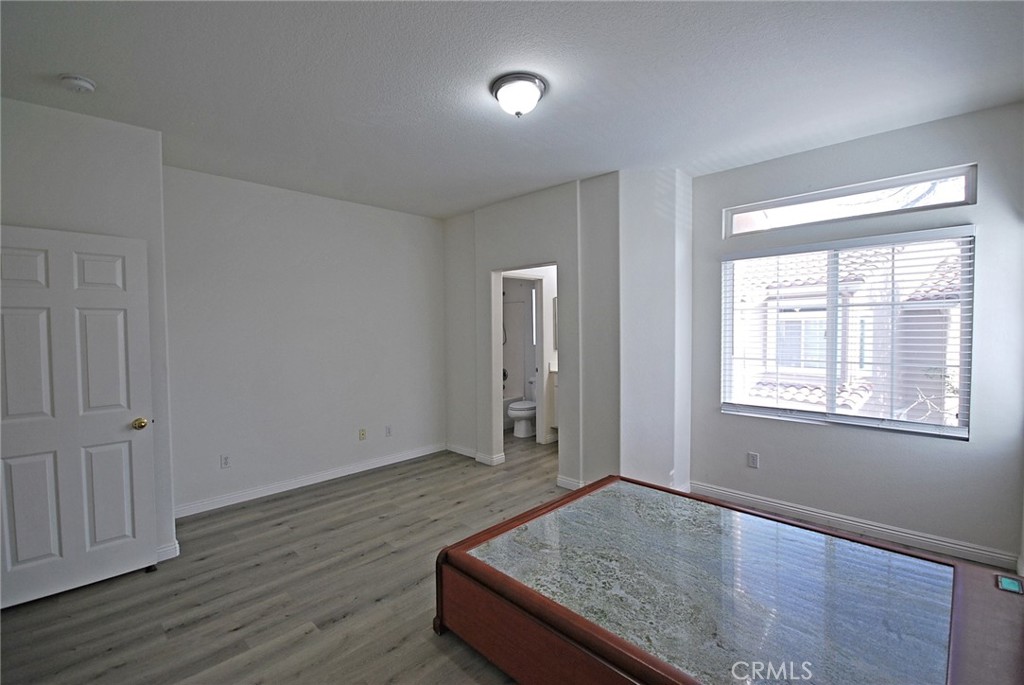 25745 Perlman Place, Unit A Stevenson Ranch, CA 91381 - Photo 14 of 28 an empty room with wooden floor and windows