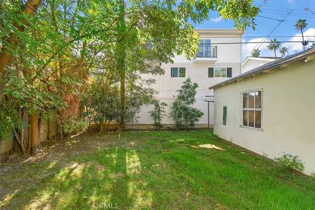 a backyard of a house with table and chairs