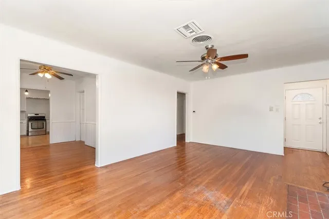 a view of an empty room and window with wooden floor
