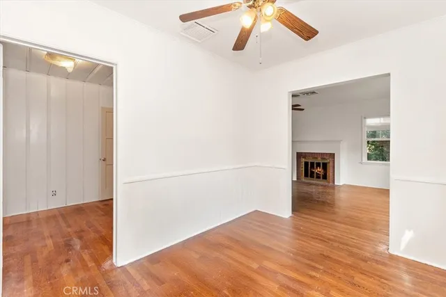 a view of a livingroom with wooden floor and a ceiling fan