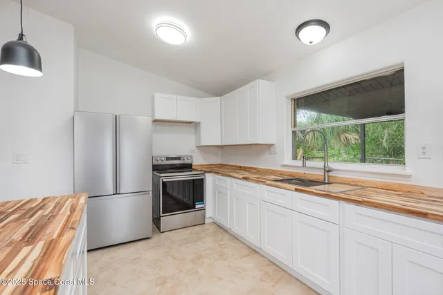 a kitchen with stainless steel appliances granite countertop a refrigerator sink and cabinets