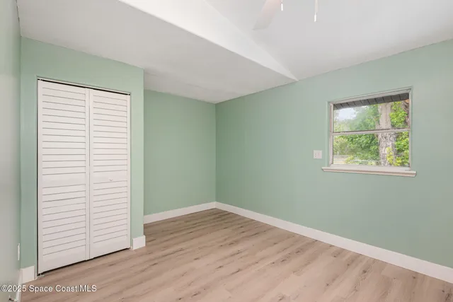 an empty room with wooden floor and a window
