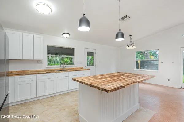 a kitchen with granite countertop a sink and a wooden floor