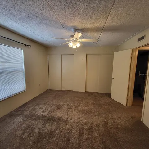 a view of an empty room with a ceiling fan