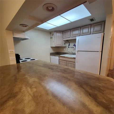 a kitchen with stainless steel appliances granite countertop a refrigerator a stove and a sink with cabinets