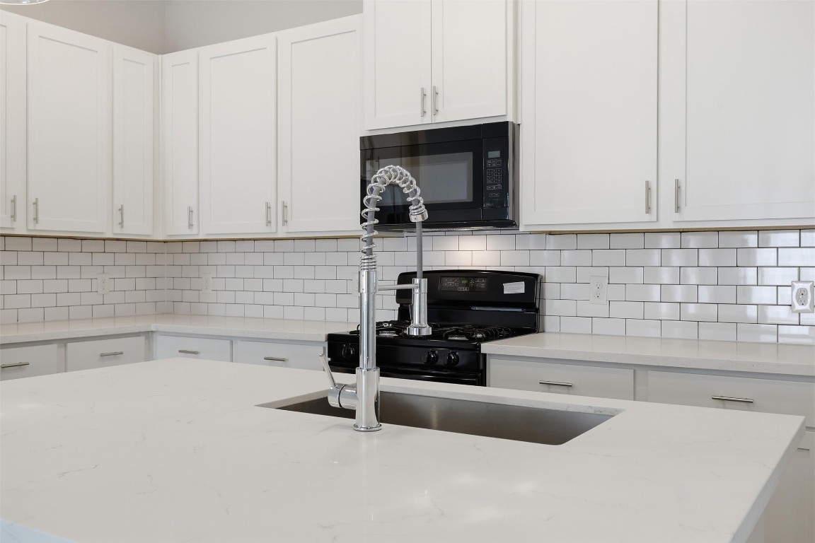 9912 Clark Road, Unit B Houston, TX 77076 - Photo 9 of 48 a kitchen with a sink and a stove top oven with wooden floor