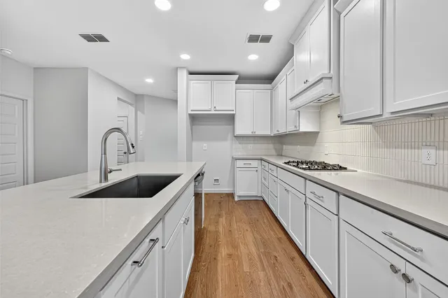 a kitchen with sink a stove and cabinets