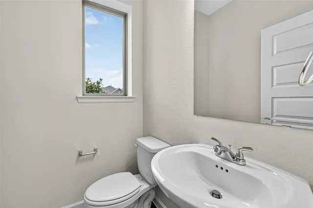 a bathroom with a sink a toilet and mirror