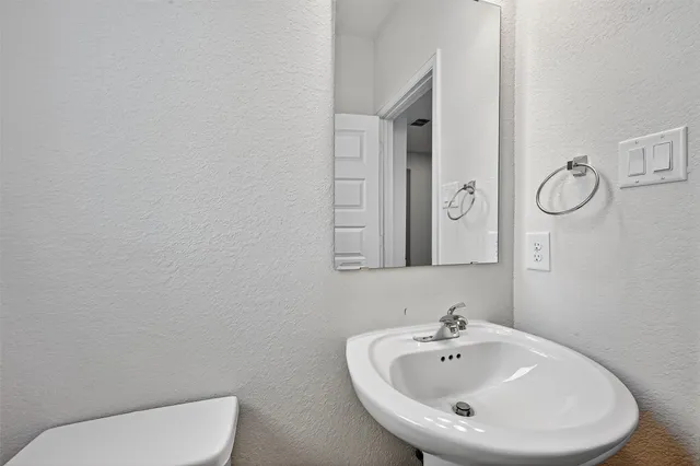 a bathroom with a toilet a sink and mirror