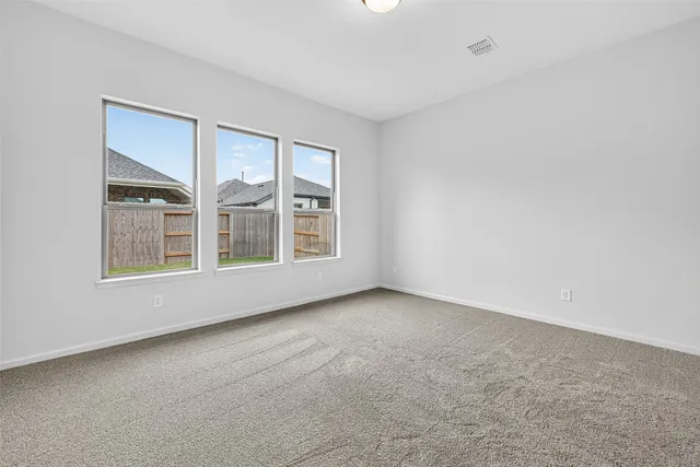 a view of an empty room and chandelier fan