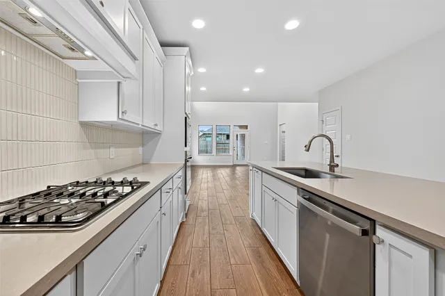 a kitchen with kitchen island stainless steel appliances a sink stove and cabinets