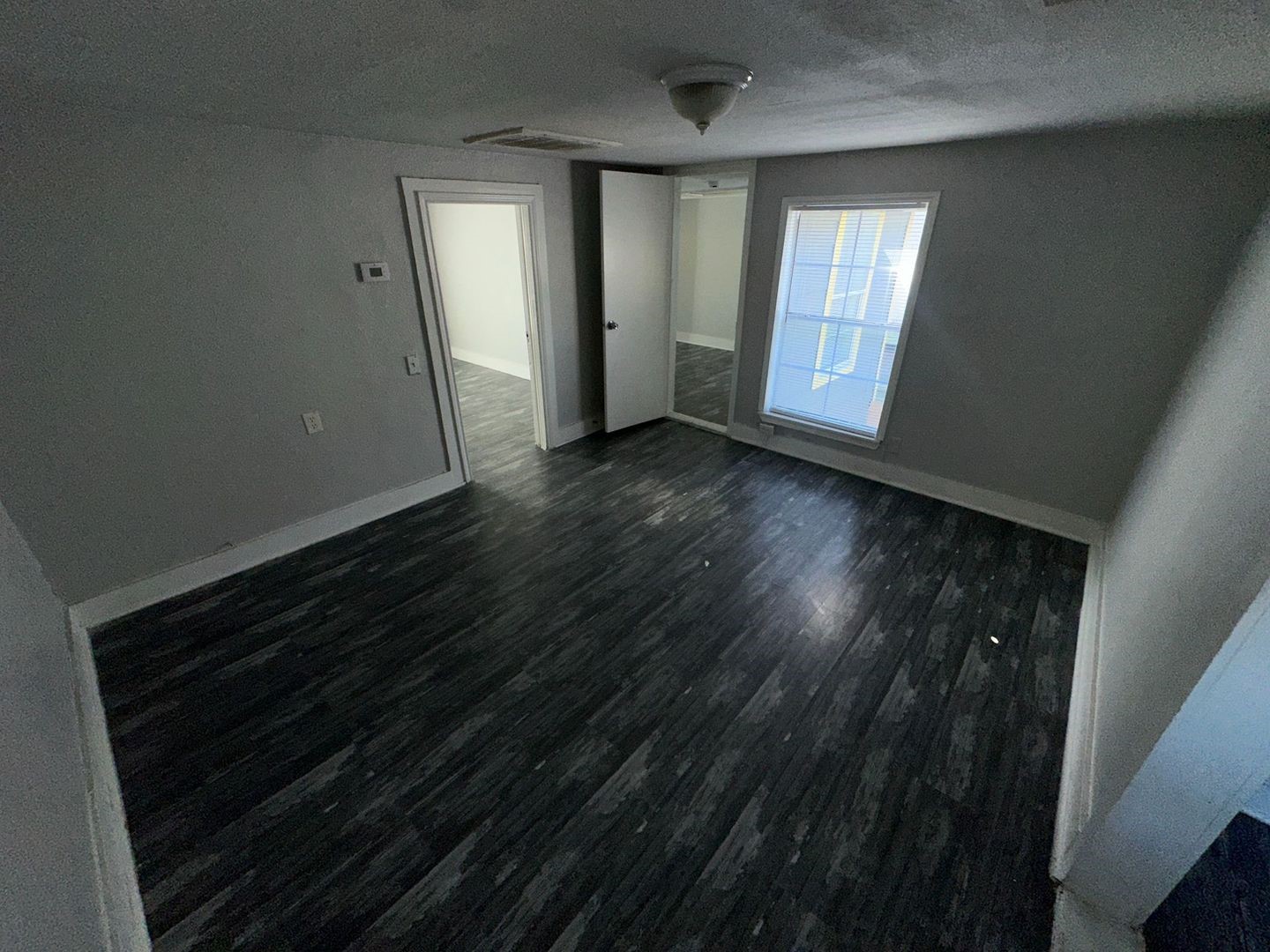 412 North 8th Street, Unit 1 Pasadena, TX 77502 - Photo 9 of 17 a view of an empty room with wooden floor and a window