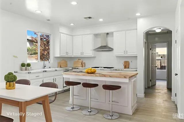 a kitchen with a stove a table and chairs in it