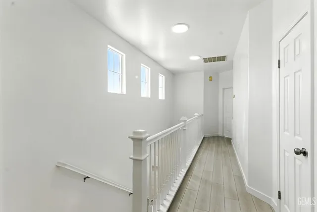 a view of a hallway with wooden floor