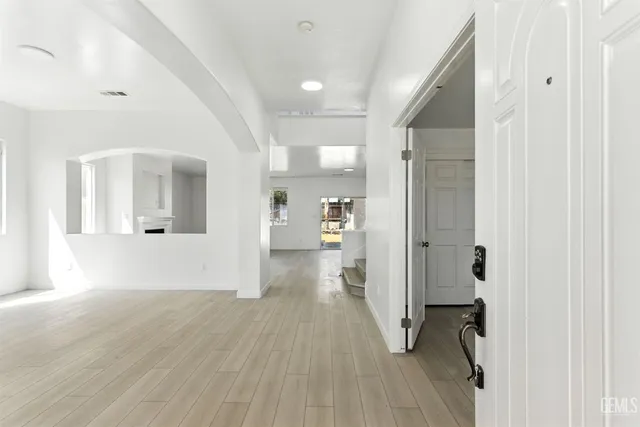 a view of a hallway with wooden floor and a living room