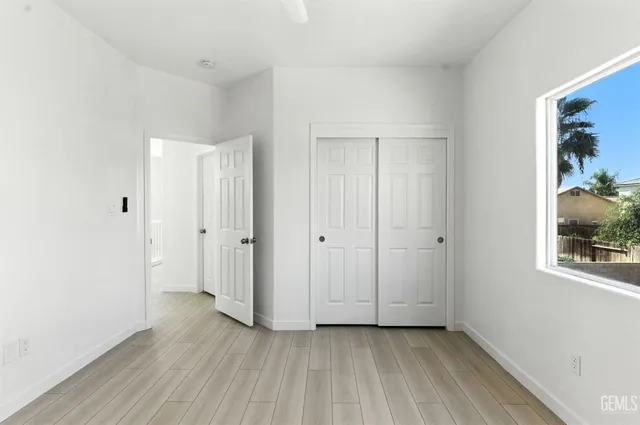 a view of a hallway with wooden floor and closet
