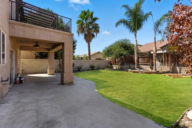 a view of a house with a yard and palm trees