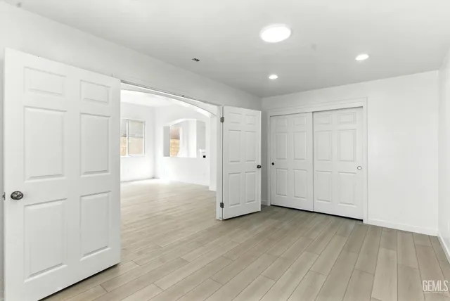a view of empty room with wooden floor