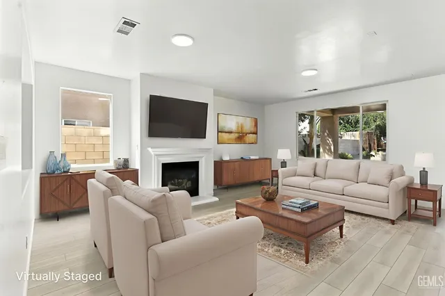 a living room with furniture a fireplace and a flat screen tv