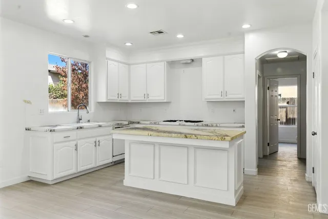 a kitchen with stainless steel appliances granite countertop a stove a sink and a refrigerator