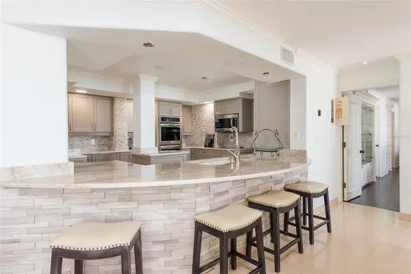a kitchen with stainless steel appliances a stove microwave and sink