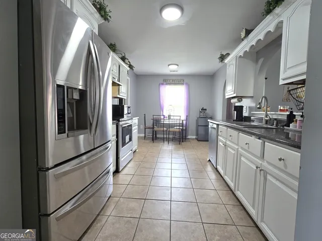 a kitchen with stainless steel appliances granite countertop a refrigerator and a sink
