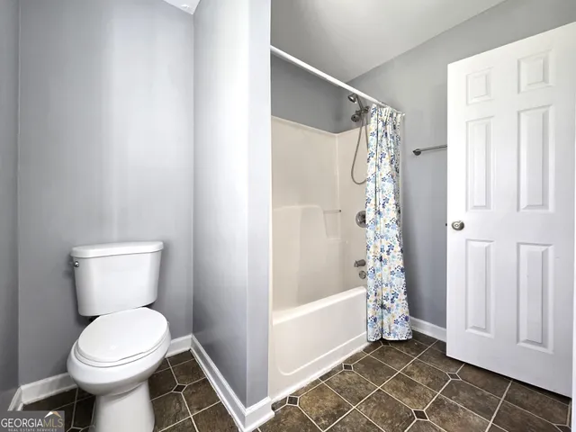 a bathroom with a toilet and a shower