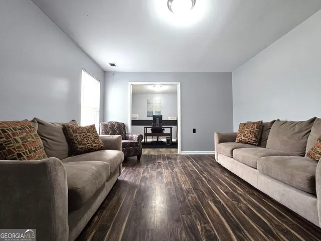 a living room with furniture and a wooden floor