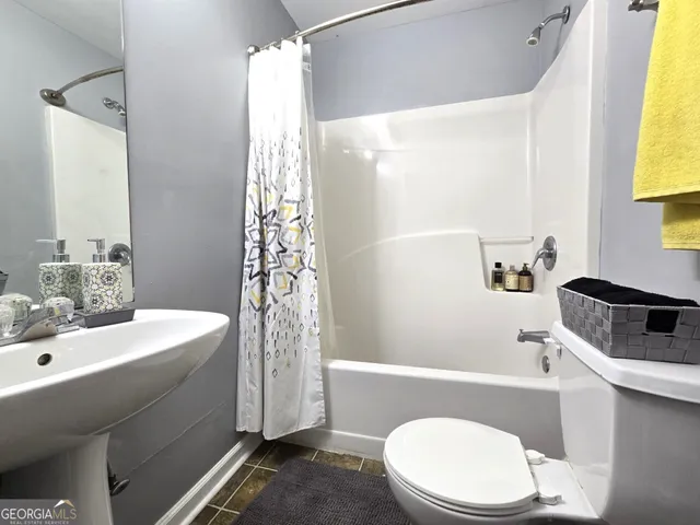 a bathroom with a sink a toilet and shower curtain