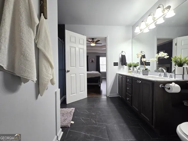 a en suite bathroom with a double vanity sink and a mirror