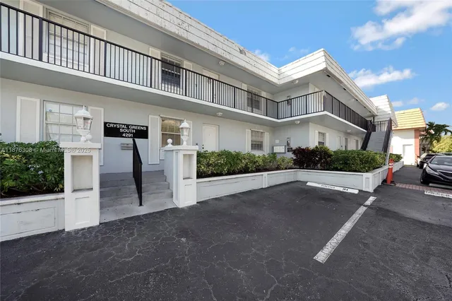 an empty room with wooden floor a ceiling fan and windows