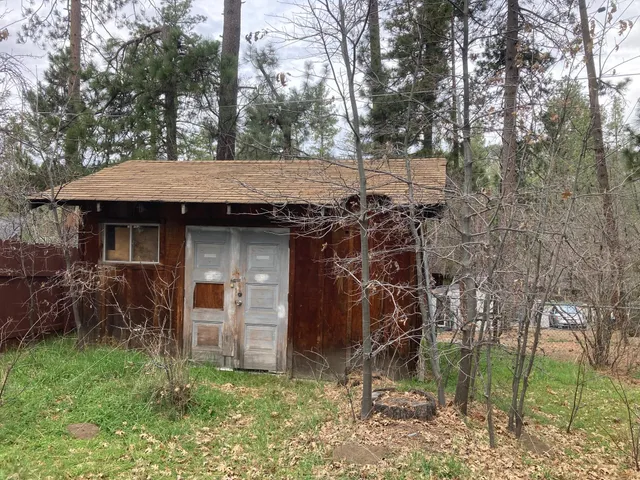 a view of a house with a yard and a large tree