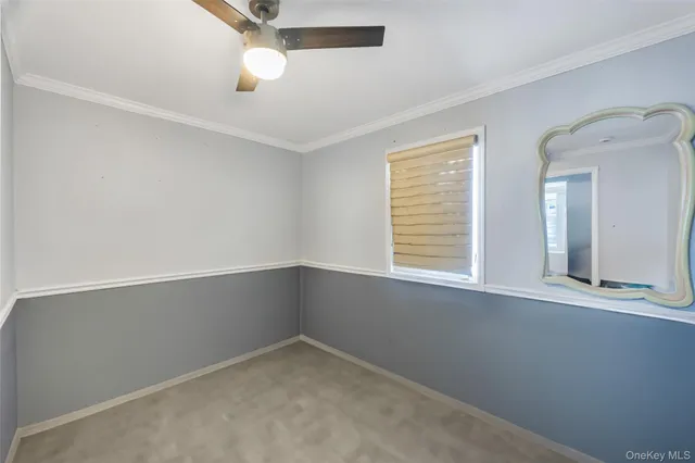 an empty room with a window and a ceiling fan