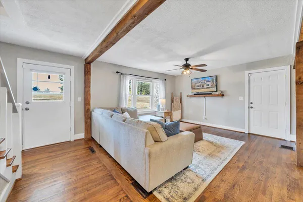 a living room with furniture wooden floor and window