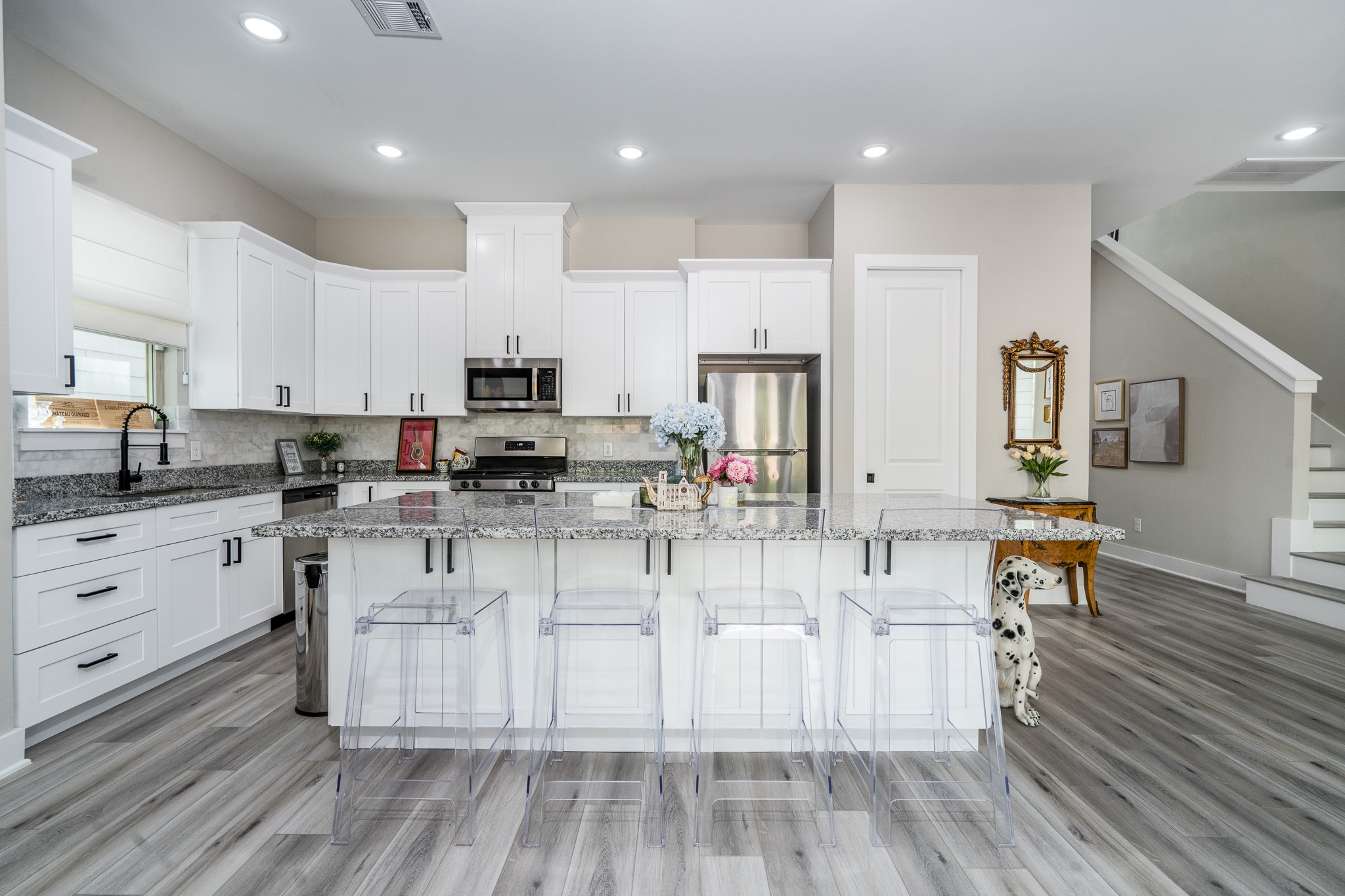 4926 Wunder Way Houston, TX 77069 - Photo 4 of 39 a kitchen with stainless steel appliances granite countertop a stove top oven a sink dishwasher and white cabinets with wooden floor