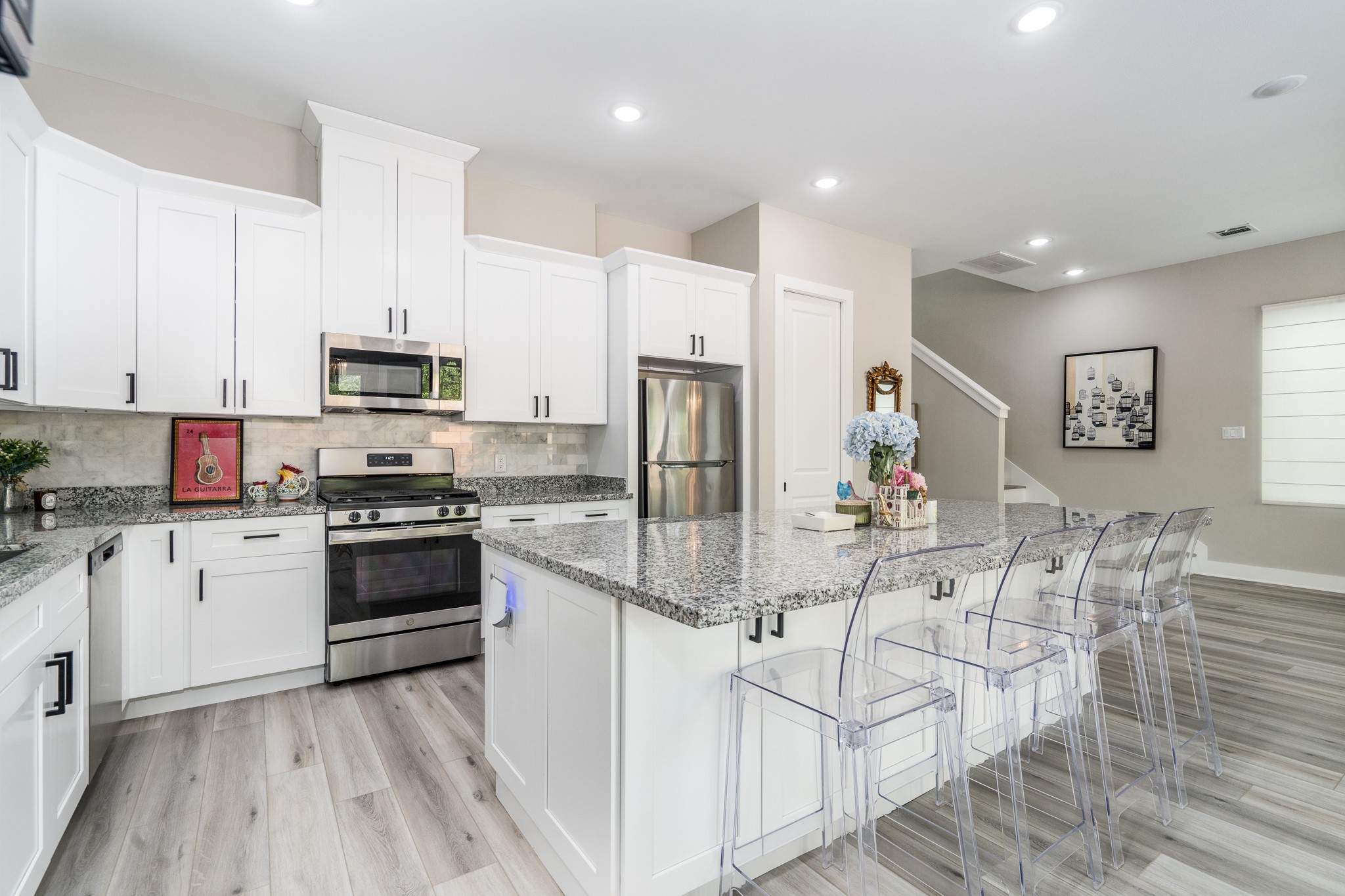 4926 Wunder Way Houston, TX 77069 - Photo 7 of 39 a kitchen with white cabinets and stainless steel appliances