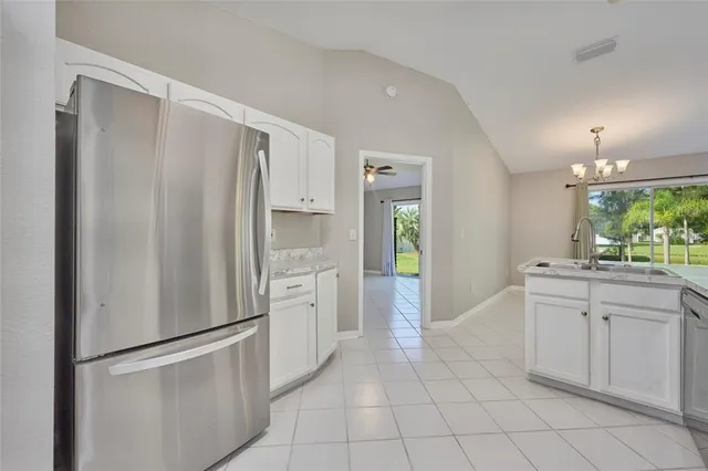 a kitchen with white cabinets and refrigerator
