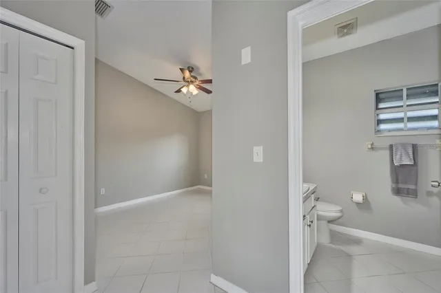 a bathroom with a granite countertop white toilet and a shower